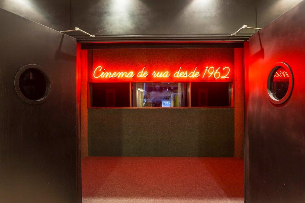 Entrada da Cinesala, com luz neon e as portas abertas