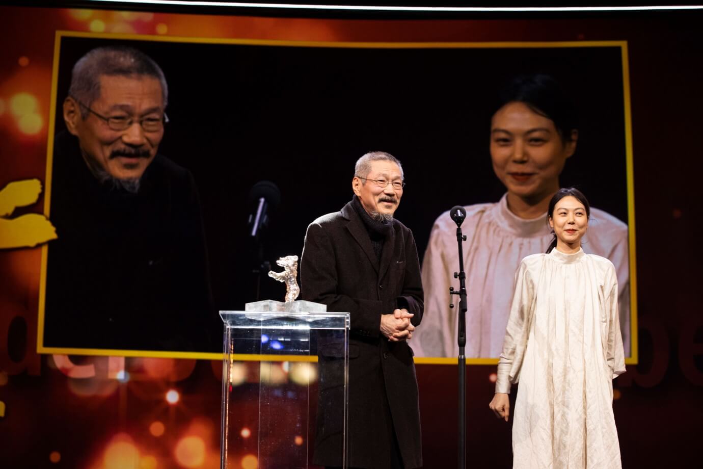 Hong Sang-soo recebendo o Urso de Prata por 'The Novelist’s Film' no Festival de Berlim de 2022, ao lado da atriz Kim Min-hee (crédito: divulgação / Berlinale)