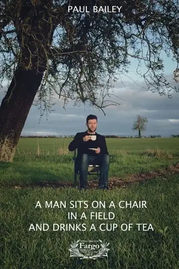 A Man Sits on a Chair in a Field and Drinks a Cup of Tea